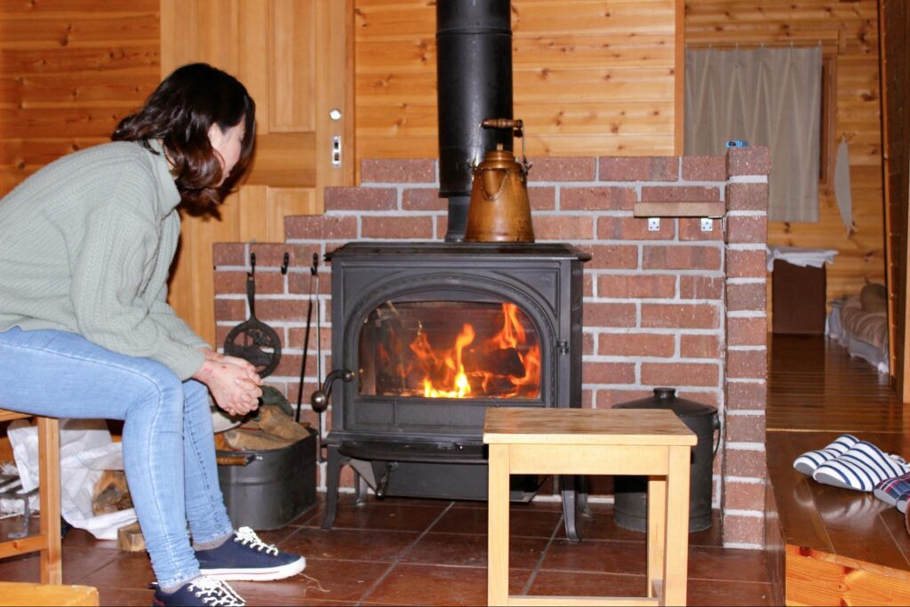 軽井沢で暖炉を見る女性