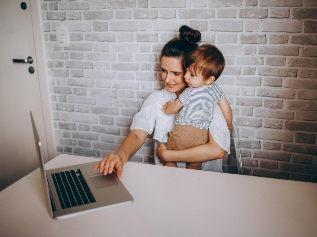 子どもを抱えながら仕事をする女性